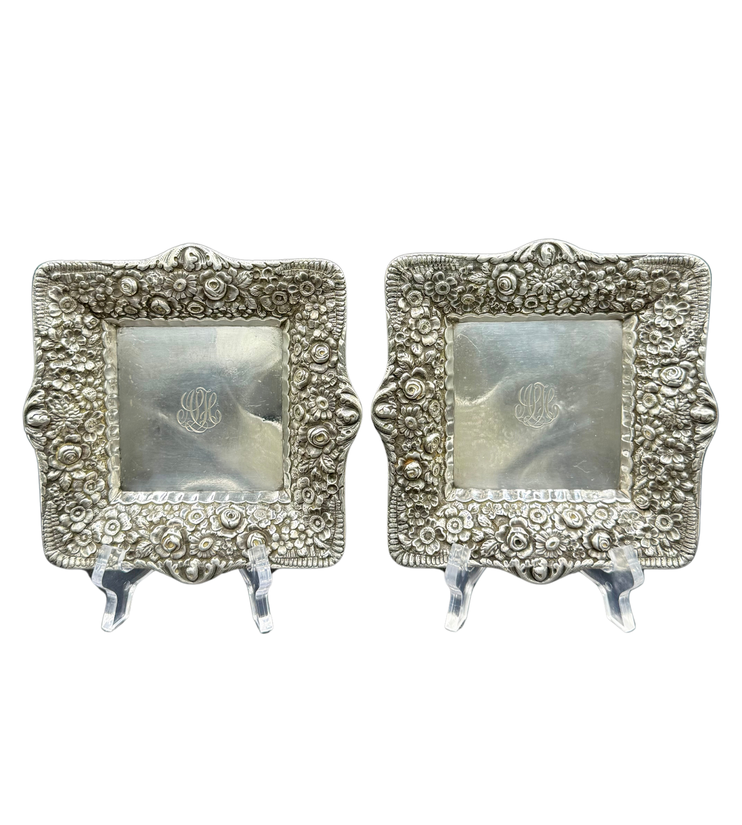 Pair of antique Tiffany & Co. repoussé sterling silver trays with floral borders and engraved monograms