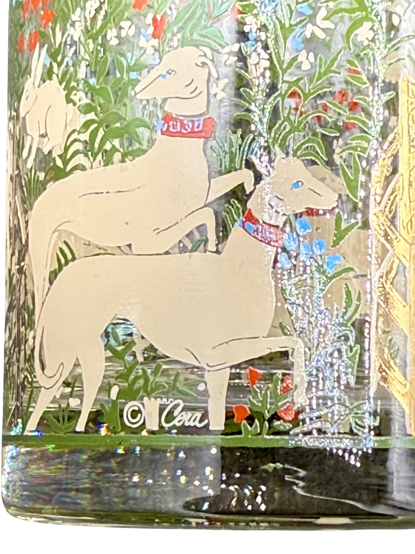 Detail of Marc Cora signature on unicorn glass, showing hounds and forest illustration in 22K gold