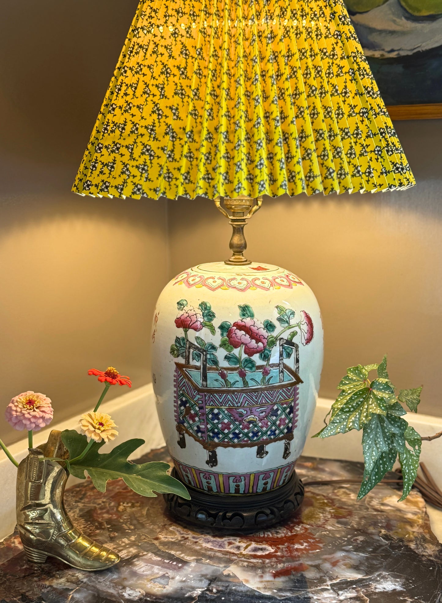 Vintage Chinese ginger jar lamp with hand-painted Famille Rose floral basket design, shown with yellow pleated shade and styled on a marble table with flowers