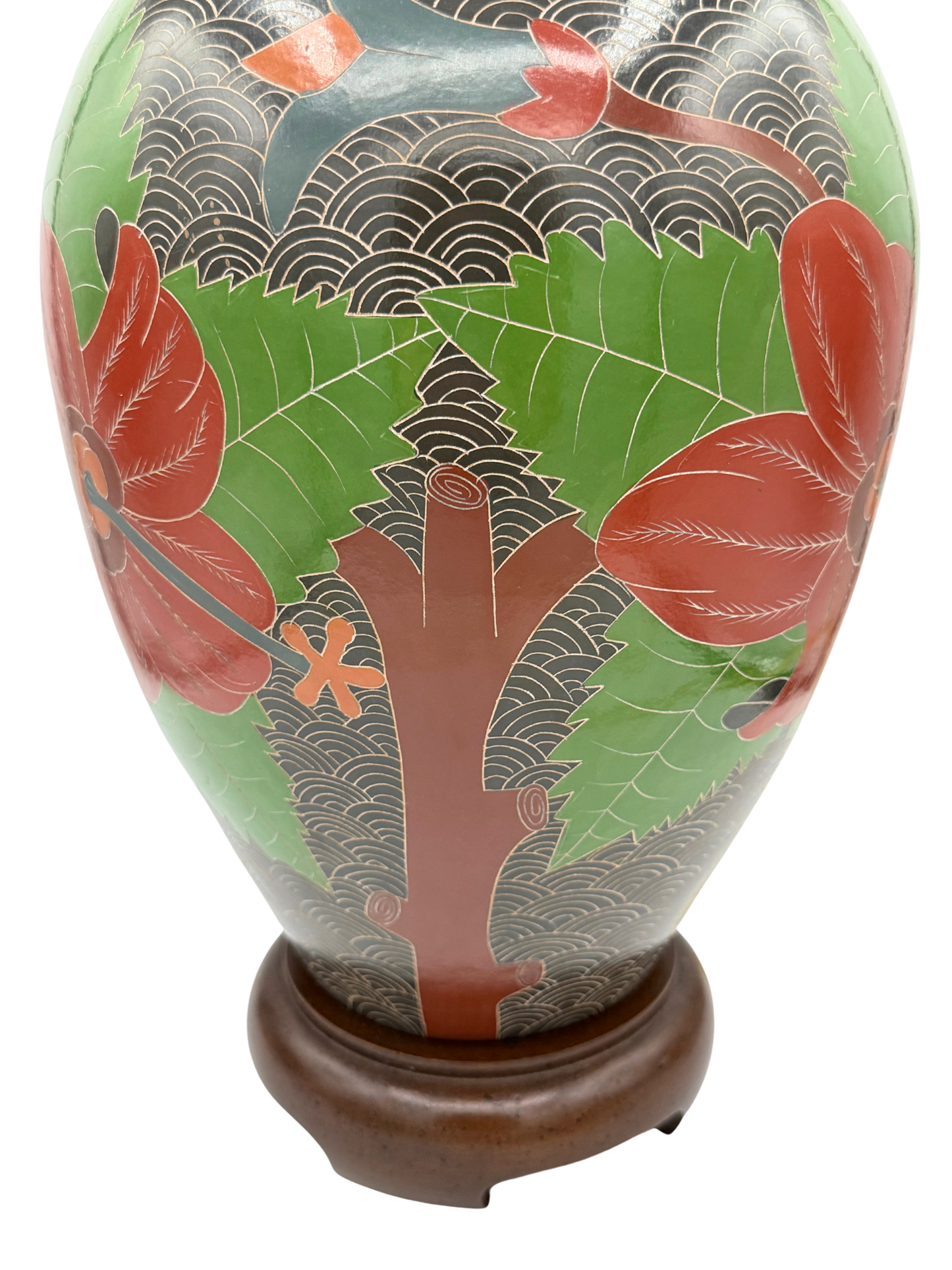Rear view of carved stoneware lamp showing floral and tree motifs in red and green against black wave background