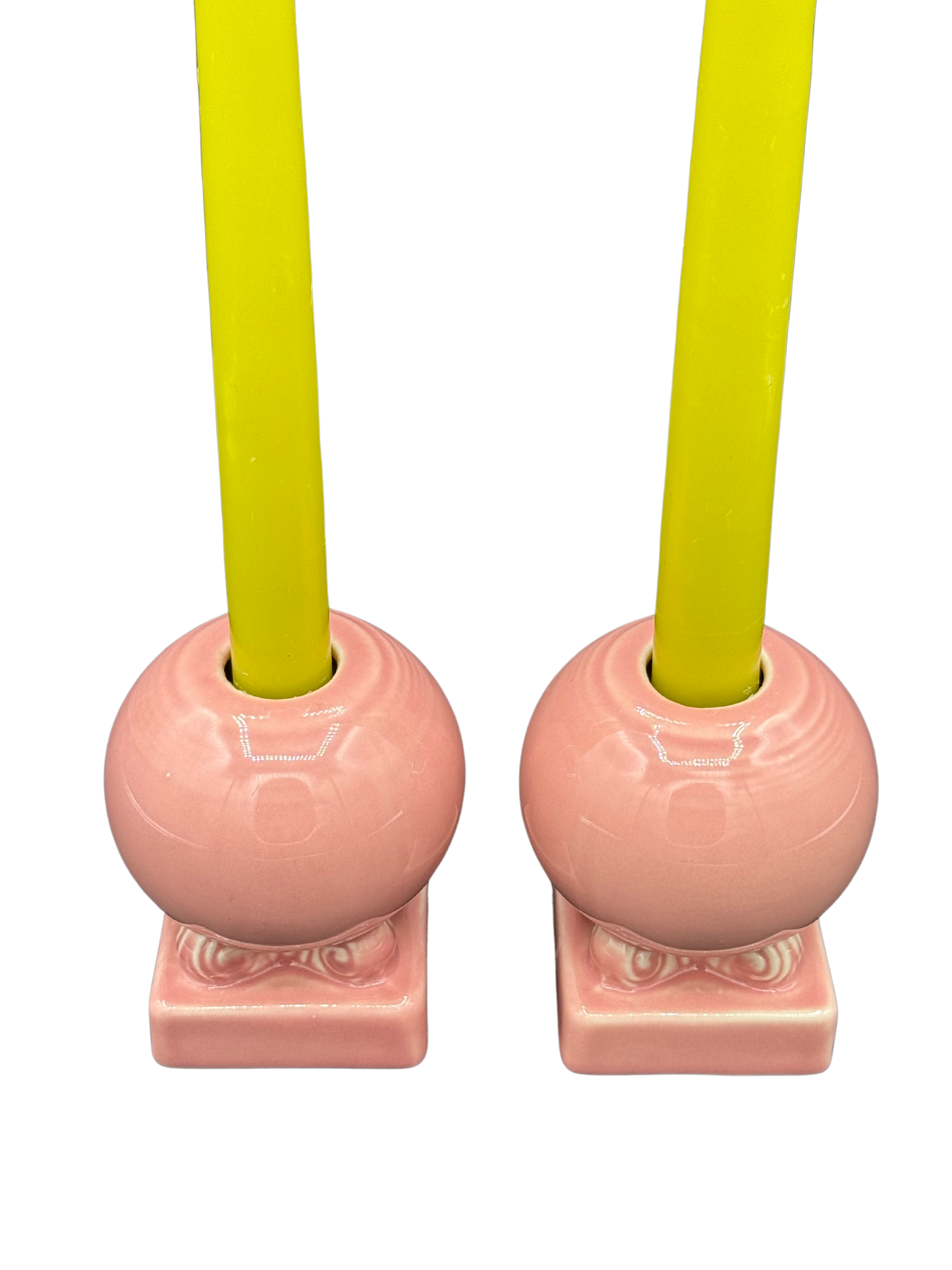 Overhead view of pink Fiestaware candle holders styled with bright taper candles