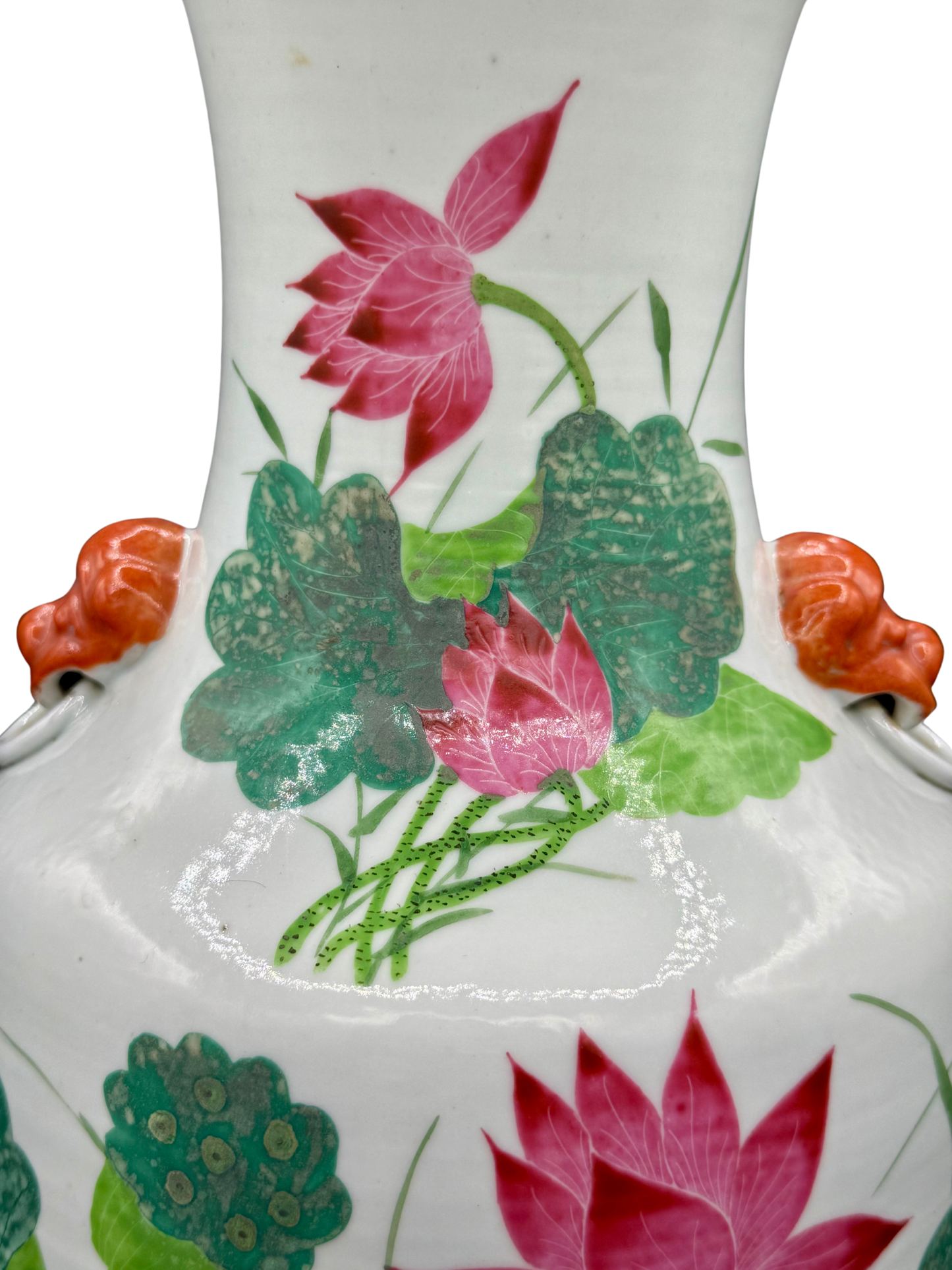 Detail of pink lotus blossoms and green foliage on antique Chinese porcelain vase with orange foo dog handles