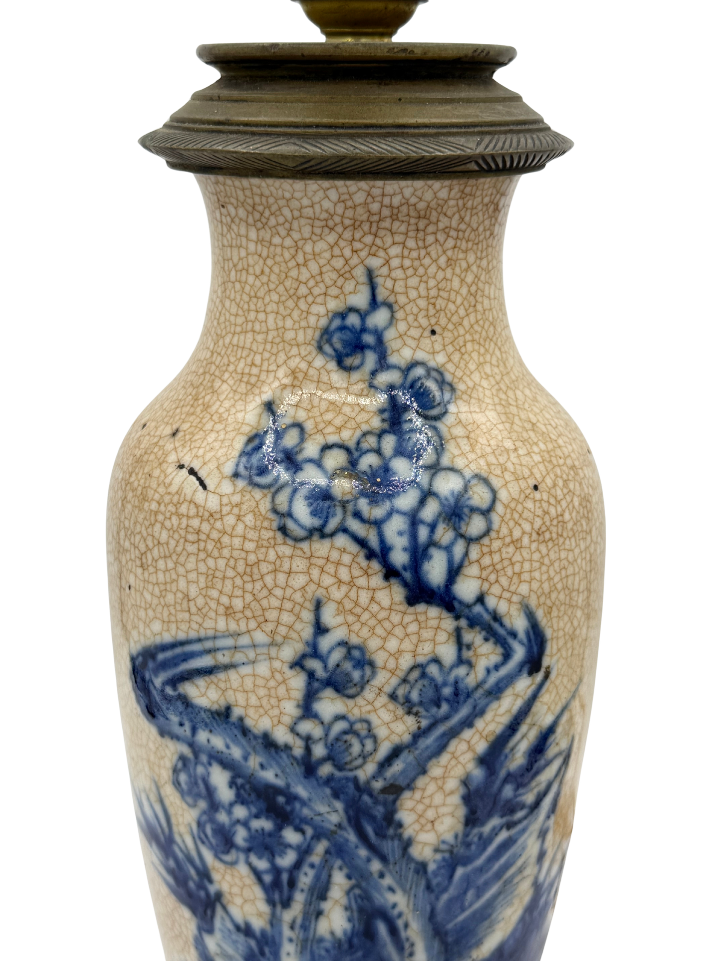 Close-up of French ceramic lamp showing hand-painted prunus blossoms in cobalt blue with visible minor crack in glaze.