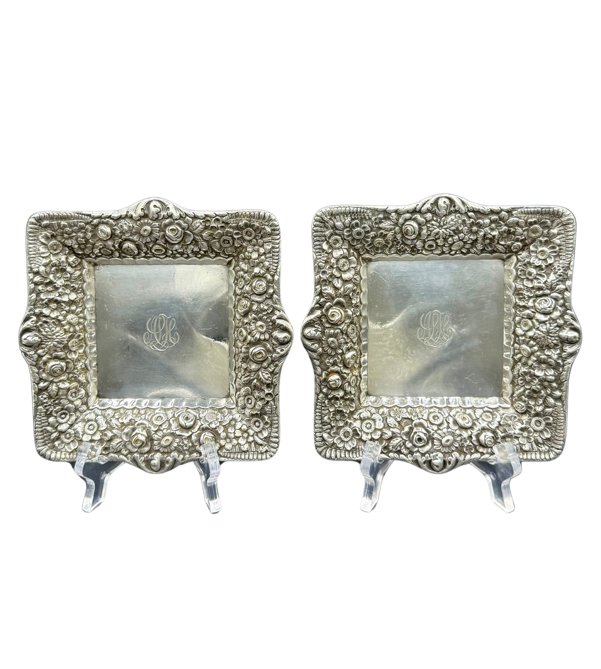 Pair of antique Tiffany & Co. repoussé sterling silver trays with floral borders and engraved monograms