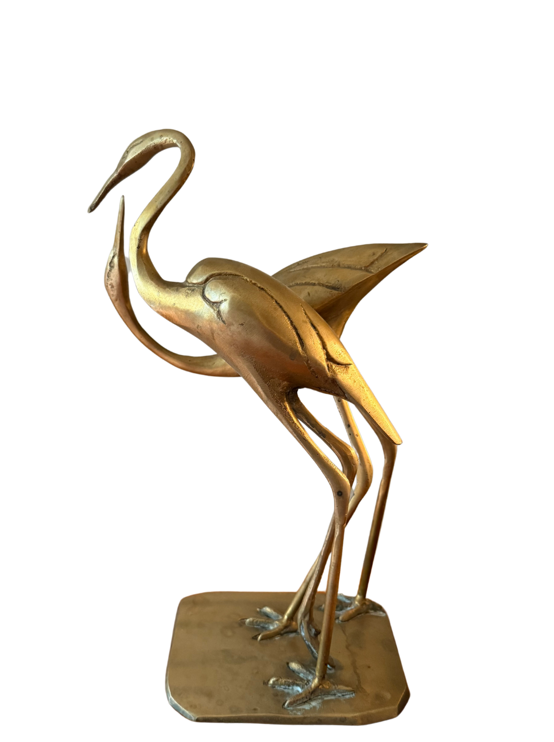 Side view of vintage brass crane pair statue, curved necks and textured wings, on shared base.