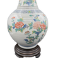 Close-up of hand-painted ceramic lamp with detailed orange, yellow, and blue flowers and fine blue border pattern