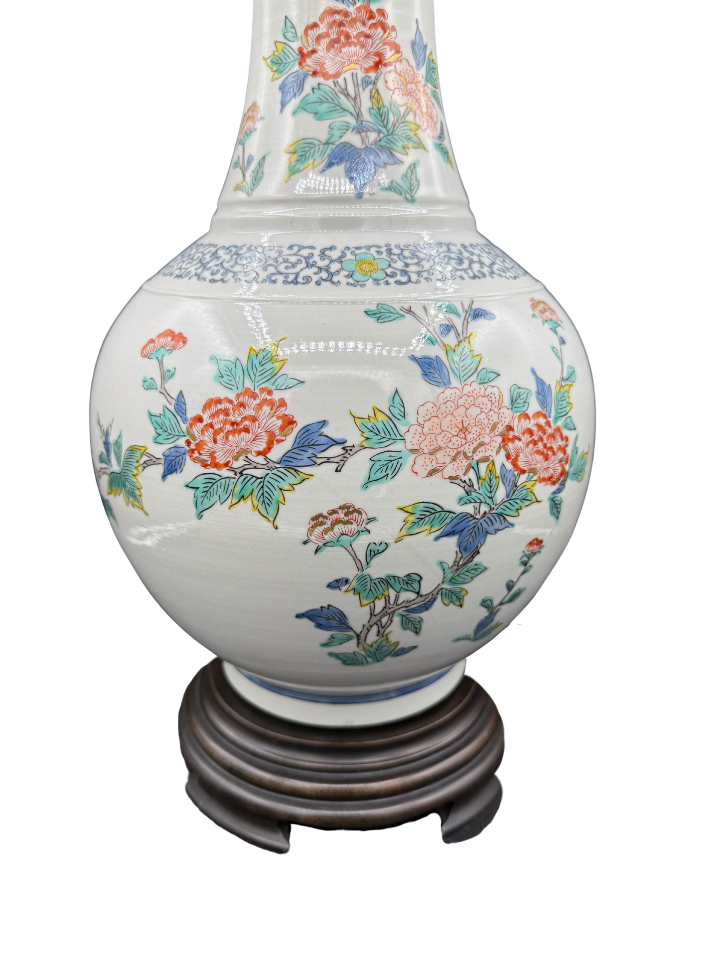 Close-up of hand-painted ceramic lamp with detailed orange, yellow, and blue flowers and fine blue border pattern
