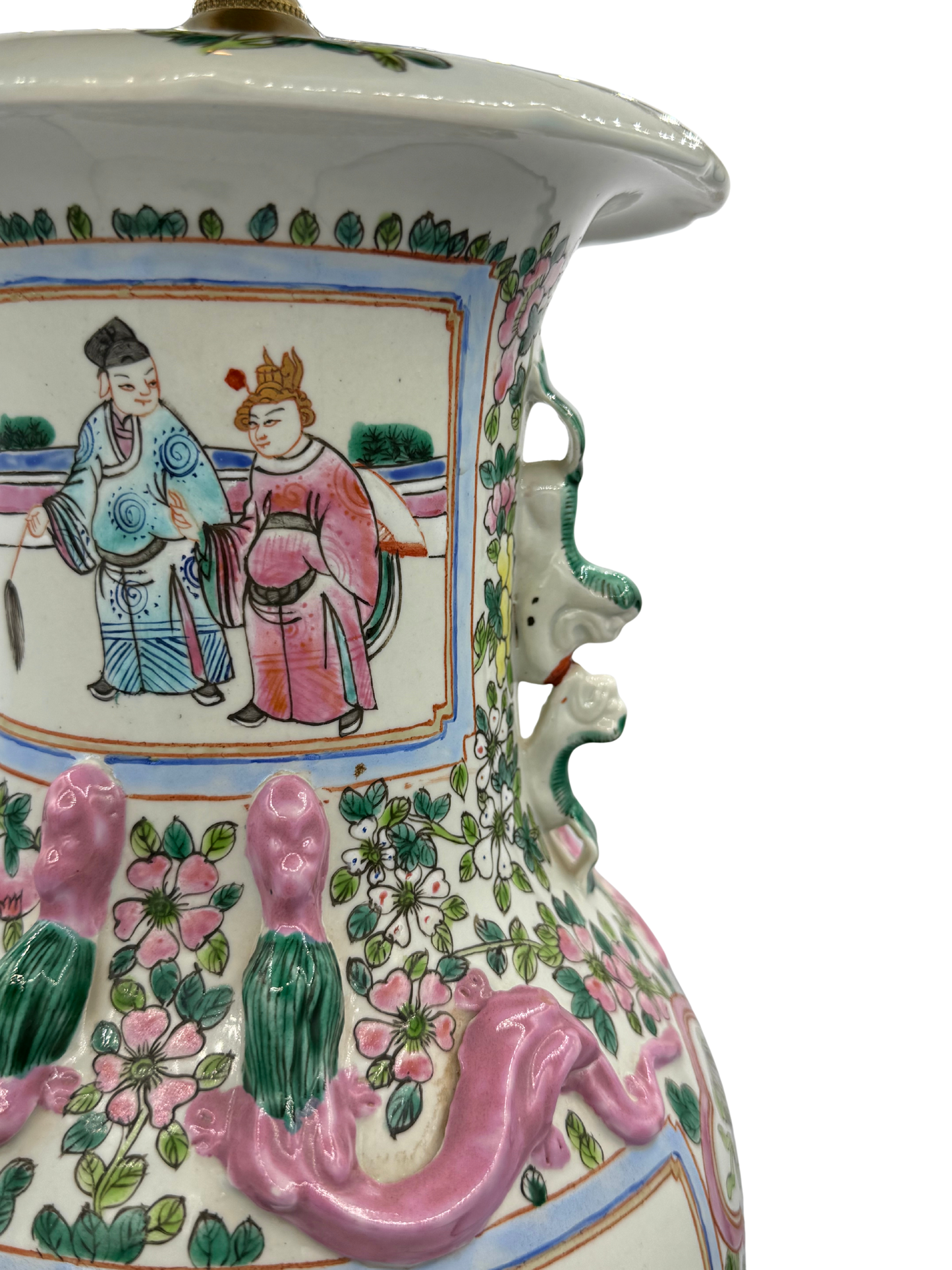 Detail of foo dog handle and high-relief dragon on a rose medallion porcelain lamp, showing hand-painted court scene and floral chinoiserie design.