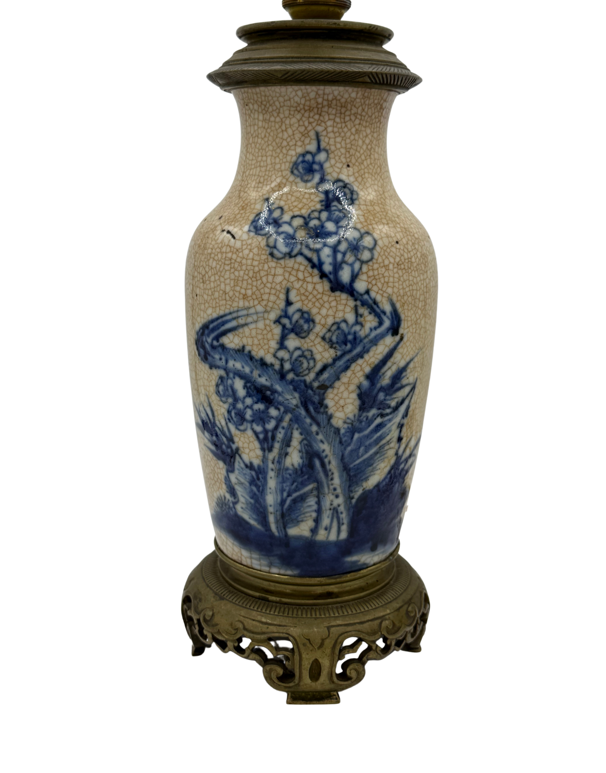 Antique French chinoiserie-style table lamp with blue underglaze floral painting, heavy crackle glaze, and ornate brass base.