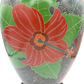 Close-up of floral carving on sgraffito stoneware lamp featuring red flower and green leaves with wave pattern background