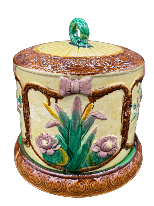 Side of Victorian cheese keeper with pink bow and iris motif in raised majolica glaze