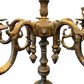 Close-up of vintage brass candelabra lamp center column and ornate scrolled arms with decorative drop finials.