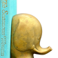 Close-up of mid-century brass elephant bookend holding turquoise book