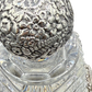 Detailed close-up of Tiffany sterling floral repoussé stopper atop antique cut crystal decanter