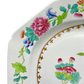 Close-up of vibrant pink peony and foliage on floral rim of antique Spode chinoiserie platter.