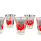 Close-up of vintage flared juice glasses with bold red cherry graphics, collectible 1940s–1960s kitchenware”