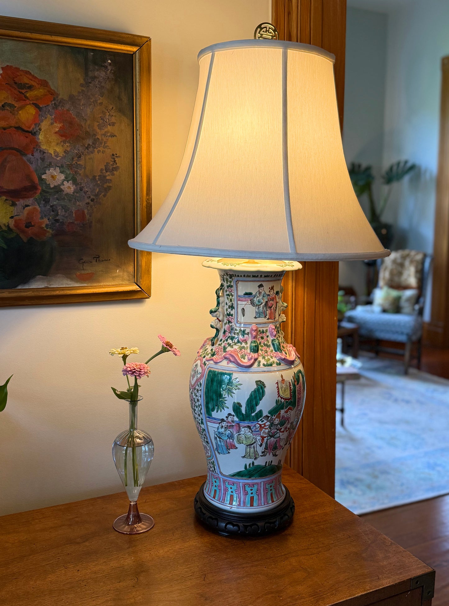 Vintage chinoiserie table lamp with fabric shade, featuring rose medallion porcelain vase, dragon imagery, and foo dog handles, styled in an interior setting.